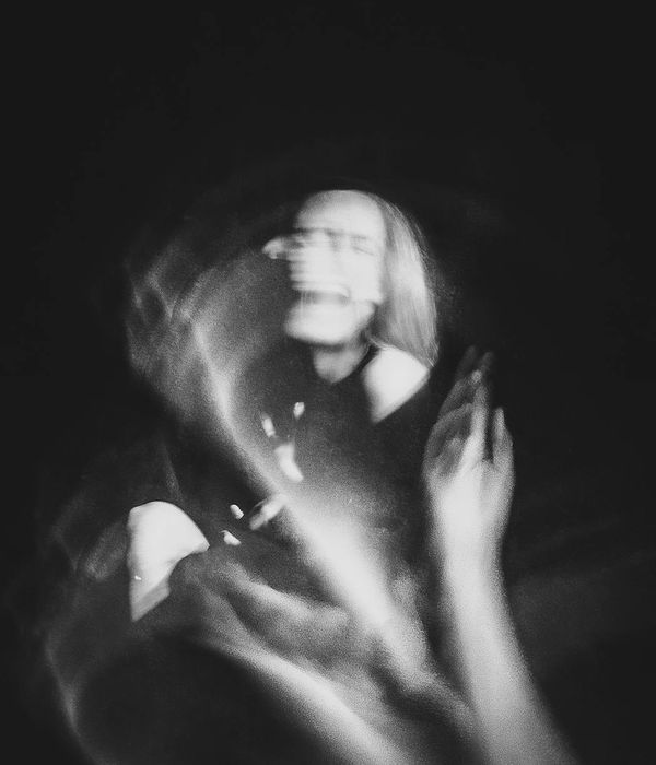 Person performing a dynamic fluid movement in a dark studio.